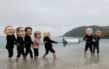 Des militants avec des masques à l'effigie des dirigeants du G7 se disputent une seringue de vaccin contre le Covid-19 lors d'une action menée par Oxfam, à Falmouth, le 11 juin 2021