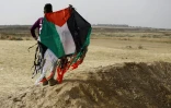 Un jeune Palestinien tient un cerf-volant aux couleurs palestiniennes près de la frontière entre la bande de Gaza et Israël, 20 avril 2018