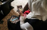 Ramia al-Sous regarde des photos de sa famille dans un appartement dans la région de la Békaa, au Liban, le 13 juin 2022