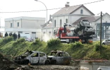 Des épaves de voiture sont enlevées près de la gare de Moirans, le 21 octobre 2015, où eu lieu des émeutes