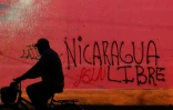 Un cycliste passe devant un graffiti réalisé au cours des manifestations contre le président Daniel Ortega, à Diriamba, à 40 km de Managua, le 124 juin 2018.
