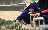 Une femme pleure sur la tombe d'un proche, dans un cimetière à Rafah, dans le sud de la bande de Gaza, le 10 avril 2024