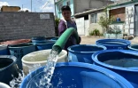 Un employé municipal remplit des tonneaux d'eau dans le district d'Iztapalapa à Mexico où des dizaines de milliers de logements n'ont pas d'eau courante, le 19 avril 2017
