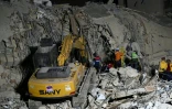 Des équipes de secours utilisent des engins de chantier sur le site d'un immeuble effondré à Caracas, le 25 juin 2026, à la suite de séismes