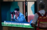 Un homme regarde à la télévision les images du dirigeant nord-coréen Kim Jong Un suivant avec des jumelles le tir de missiles balistiques nord-coréens, le 31 juillet 2019 dans une gare de Séoul, en Corée du Sud