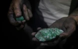 Un chercheur d'émeraudes montre ses découvertes dans une mine à Muzo, département de Boyaca, Colombie, le 18 juin 2024