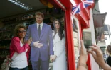 Une touriste pose avec un portrait en carton du prince Harry et de sa fiancée Meghan Markle à Windsor le 8 mai 2018