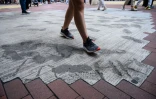 Des habitants de Hong Kong foulent le 2 juin 2020 un trottoir dont les pavés ont été remplacés par du béton par les autorités locales, en réponse aux manifestations pro-démocratie.