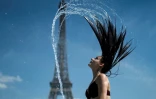 Une femme se rafraîchit dans une fontaine de l'esplanade du Trocadéro à Paris, le 25 juin 2019