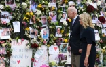 Le président américain Joe Biden et sa femme Jill Biden se recueillent devant un mur du souvenir en hommage aux 18 personnes décédées et aux 140 toujours portées disparues dans l'effondrement d'un immeuble, le 2 juillet 2021 à Surfside, en Floride