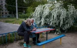 Des femmes, évacuées du village de Rouska Lozova, dans une cour de l'école maternelle 420 du district Osnoviansky, le 18 mai 2022 au sud de Kharkiv, en Ukraine
