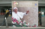 Des travailleurs installent une affiche dans le stade Gelora Bung Karno de Jakarta le 3 septembre 2024 avant la grand-messe du pape François