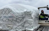 Une cargaison de masques de protection est déchargée d'un avion cargo arrivant de Chine, le 29 mars 2020 à l'aéroport parisien de Roissy-Charles de Gaulle