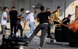 Des Palestiniens lancent des pierres sur les forces israéliennes qui mènent une opération à Naplouse en Cisjordanie occupée, le 9 août 2022 