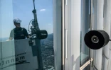 Seo Seung-ho nettoie les vitres du plus haut gratte-ciel de Séoul, le Lotte World Tower, depuis une "nacelle" suspendue par des câbles au 125e étage du bâtiment, le 4 juin 2024 à Séoul, en Corée du Sud