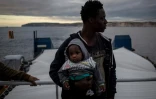 Un migrant tenant un bébé regarde la côte maltaise depuis le pont du Sea Watch 3, le 9 janvier 2019