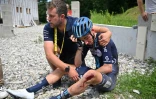 Le coureur cycliste français Romain Bardet (à droite) après sa chute qui l'a contraint à l'abandon lors de la 14e étape du 110e Tour de France entre Annemasse et Morzine le 15 juillet 2023.