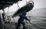 Des soldats de la Marine roumaine remontent un canot de sauvetage Ă bord d'un chasseur de mines, lors d'un exercice en mer Noire, le 16 avril 2024 au large du port roumain de Constanta