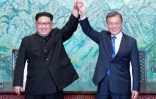 Le président sud-coréen Moon Jae-in (d) et le leader nord-coréen Kim Jong Un main dans la main à l'issue du sommet intercoréen, le 27 avril 2018 à Panmunjom