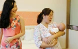 Xu Jingfang (g), la maman du petit Kirk bercé par une nounou, au Centre post-natal international du lac Malaren, le 17 mai 2018 à Shanghai