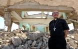 Le cardinal Philippe Barbarin marche parmi les ruines de l'église assyrienne des Martyrs ne reste plus que des murs défoncés, à Mossoul le 25 juillet 2017