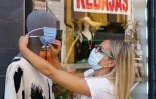 Une vendeuse place un masque sur un mannequin à Aranda de Duero, le 7 août 2020 en Espagne