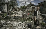 Ivan Sosnin, 19 ans, marche dans la cour de sa maison détruite le 7 juin 2022 à Lyssytchansk, dans l'est de l'Ukraine