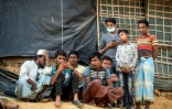Des réfugiés Rohingyas regardent sur un téléphone portable le procès intenté à la Birmanie devant la Cour internationale de justice de La Haye, le 11 décembre 2019 dans un camp à Ukhia, au Bangladesh