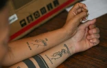 Mervin Yamarte, un migrant vénézuélien rapatrié d'une prison au Salvador, et sa femme montrent leurs tatouages lors d'une interview avec l'AFP dans le quartier de Los Pescadores à Maracaibo, au Venezuela, le 23 juillet 2025