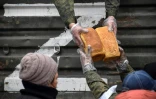 Des soldats et bénévoles russes distribuent du pain aux habitants de Marioupol, la ville portuaire dévastée du sud de l'Ukraine, le 12 avril 2022