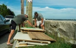 Deux membres d'une association de plage privée démontent une cahute de plage en prévision du passage de l'ouragan Henri, à New London (Connecticut), le 21 août 2021