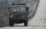 Un camion militaire russe avance sur une route dans la région de Rostov, frontalière du territoire séparatiste de Donetsk dans l'Est de l'Ukraine, le 23 février 2022