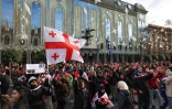 Des manifestants hostiles au nouveau président géorgien Mikheïl Kavelachvili brandissent des cartons rouges en référence à son passé de footballeur 29 décembre 2024 devant le Parlement de Tbilisi