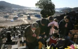 Des Japonais se recueillent sur la tombe de leurs proches le 11 mars 2017 à Otsuchi