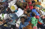 Des réfugiés rohingyas dorment sur une pile de vêtements à leur arrivée au camp temporaire de Lhokseumawe en Indonésie, le 8 septembre 2020