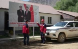 Des employés de l'entreprise Talco Gold, devant une affiche du président chinois Xi Jinping (d) et du président tadjik Emomali Rakhmon à la mine d'antimoine de Saritag, dans l'ouest du Tadjikistan, le 26 août 2025