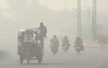 Des Pakistanais se rendent au travail dans la ville de Lahore recouverte d&rsquo;un épais smog, le 5 juin 2022