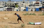 Un jeune Palestiniens tire des sacs récupérés dans une décharge au camp d'Al-Bureij, dans le centre de la bande de Gaza, le 7 juillet 2025