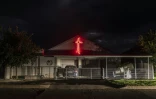 Une croix de lumière rouge orne la façade de la maison d'habitants de l'enclave afrikaner d'Orania en Afrique du Sud, le 28 janvier 2026.