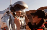Des techniciens aident un astronaute d'une équipe d'Europe et d'Israël à revêtir une combinaison spatiale avant  une mission d'entraînement sur un site qui simule une station hors site au cratère Ramon à Mitzpe Ramon dans le désert du sud du Néguev, en Israël, le 10 octobre 2021