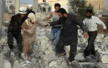 Des secouristes syriens aident une femme blessée à se sortir des décombres, après une frappe aérienne des forces gouvernementales contre le quartier d'Hadariya tenu par les rebelles, le 10 avril 2016 à Alep