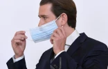 Le chancelier autrichien  Sebastian Kurz enlève sa masque de protection lors d'une conférence de presse le 6 avril 2020 à Vienne portant sur l'épidémie de coronavirus.