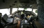 Près d'Abidjan, entre forêt verte et lagune, un employé d'Aziz Alibhai dans le cockpit d'une épave d'avion qu'il rêve de transformer en une attraction touristique atypique, le 15 avril 2022 à Songon Dagbe dans la région de Jacqueville, en Côte d'Ivoire