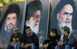 Des Libanais assis devant des portraits d'Hassan Nasrallah, chef du Hezbollah (à gauche), du fondateur de la République d'Iran, l'Ayatollah Khomeini (droite), et du Guide suprême iranien, Ali Khamenei (centre), à Kfour, au Liban, le 1er mars 2016