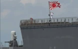 Un marin hisse le pavillon des Forces maritimes d'autodéfense japonaises à bord du JS Ise, un destroyer porte-hélicoptères de classe Hyuga, lors de son arrivée au port international de Manille, le 21 juin 2025 aux Philippines
