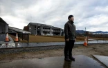 Yuto Naganuma, 26 ans, devant les bâtiments endommagés de l'école primaire où son petit frère a perdu la vie pendant le tsunami de 2011, le 7 février 2021 à Ishinomaki, au Japon