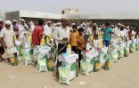Des Yéménites déplacés de la ville d'Hodeida reçoivent une aide alimentaire d'une ONG japonaise, le 15 août 2018 à Al Hajjah