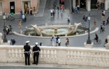 Des policiers muncipaux surveillent les passants place d'Espagne à Rome le 17 mai 2020
