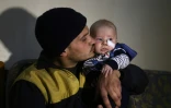 Saïd al-Masri, un secouriste dans la localité syrienne de Saqba dans la Ghouta orientale, avec son bébé de trois mois qu'il a sauvé sous les décombres, le 12 février 2018