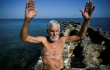 Orestes Quintana, 87 ans, membre du club "Jeunesse accumulée", s'échauffe avant de nager dans une piscine d'eau de mer à La Havane, le 17 mai 2025
